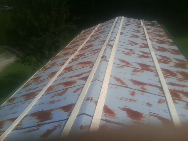 Rusted metal roof panels with new wood purlins before replacement — Storm Damage Roof Repair in Tracys Landing by Roofing Brothers