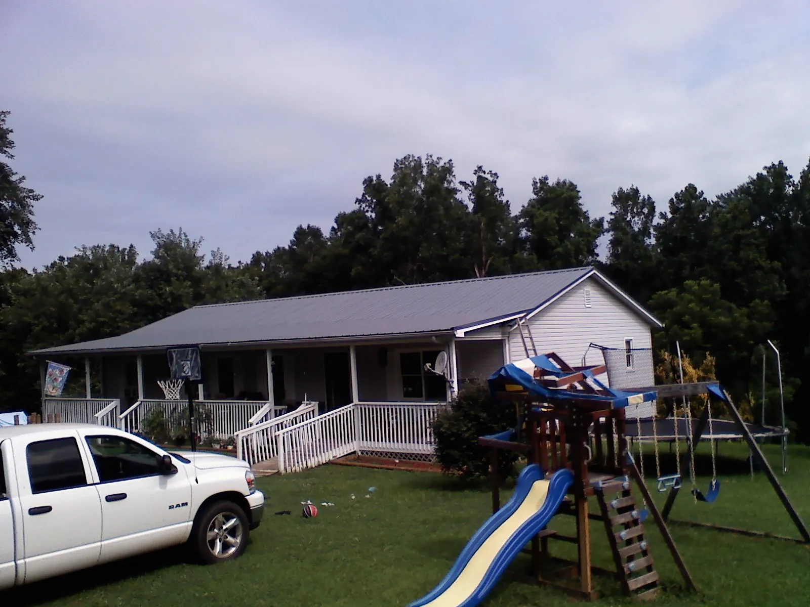 Dark metal roof on a country home with a full length front porch in Tracys Landing